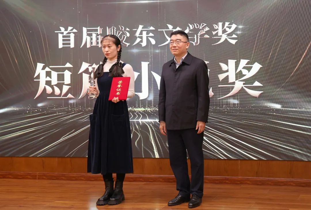 山東省作協(xié)黨組書記、副主席趙藝?。ㄓ乙唬? 為短篇小說獎(jiǎng)獲得者王銘嬋頒獎(jiǎng)