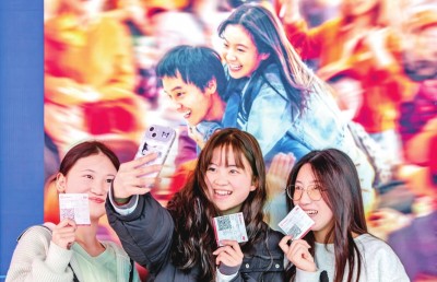 2月18日，觀眾在貴州省黔西市一家影院的電影海報前留影。 新華社發(fā)