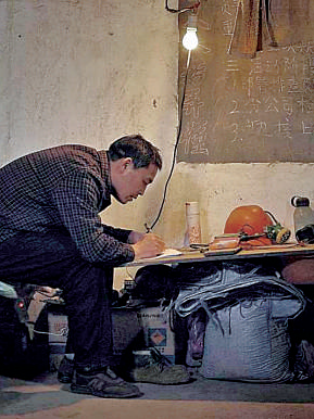 礦工陳年喜在燈下寫作。資料圖片