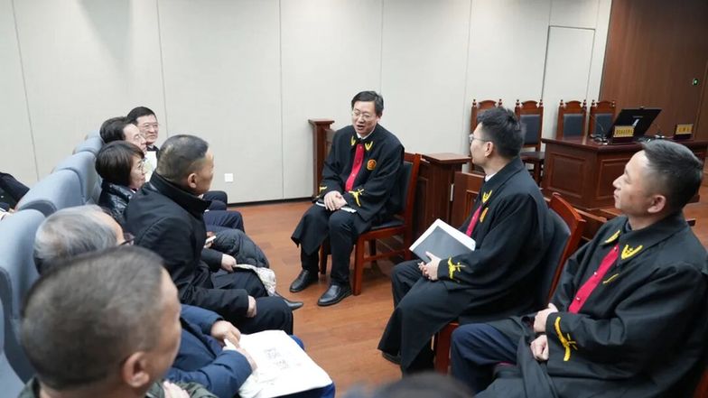 圖為采風(fēng)作家們在合肥法務(wù)區(qū)旁聽庭審后，與主審法官交流。